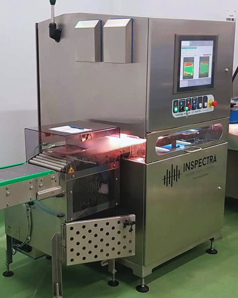 Packaged meat inspection system with conveyor moving product under imaging technology