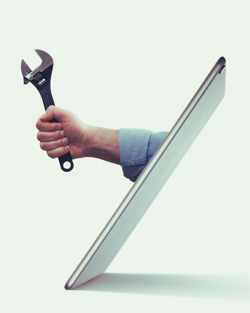 Hand holding a tool reaching out from an ipad screen